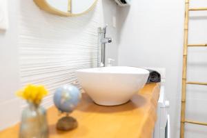 a bathroom with a bowl sink on a wooden counter at La lumière du Midi-Oncopole à 5 minutes-clim in Toulouse +29 photos