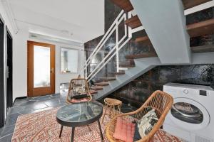 a living room with a staircase and a table and chairs at La lumière du Midi-Oncopole à 5 minutes-clim in Toulouse