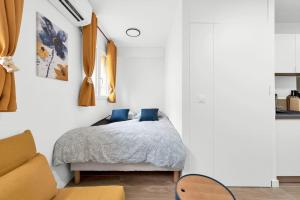 a bedroom with a bed with blue pillows at La lumière du Midi-Oncopole à 5 minutes-clim in Toulouse