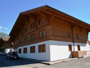 un grande edificio in legno con un'auto parcheggiata di fronte di Apartment Jacqueline 1 by Interhome a Gstaad