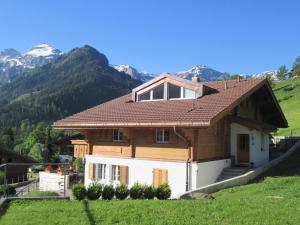 ein Haus auf einem Hügel mit Bergen im Hintergrund in der Unterkunft Apartment Isabelle by Interhome in Lenk im Simmental