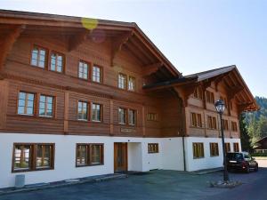 un grand bâtiment en bois avec une voiture garée devant dans l'établissement Apartment Jacqueline 11 by Interhome, à Gstaad