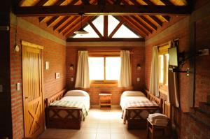 Habitación con 3 camas y ventana en Cabanas El Yarquen en Sierra de los Padres