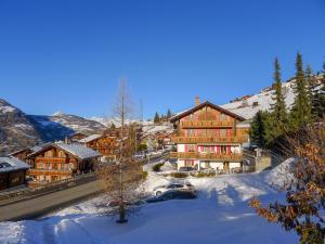 un grande edificio nella neve in una città di Apartment Bergfink Obergeschoss-4 by Interhome a Grächen