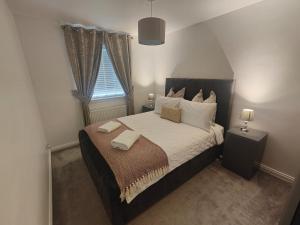 a bedroom with a bed with two towels on it at Lovely 2 Bedroom Modern Ground Floor Flat in Clydebank