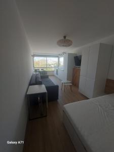 um quarto com uma cama, um sofá e uma mesa em Studio vue port à 50m plage em Carnon-Plage