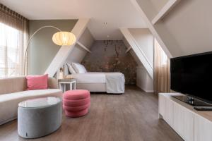 ein Wohnzimmer mit einem Sofa und einem Bett in der Unterkunft Juuls Domburg in Domburg