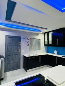 a kitchen with a blue light and a black door at Icebolethu Guest House in Standerton