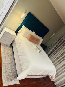 a bed with a blue headboard in a room at Icebolethu Guest House in Standerton