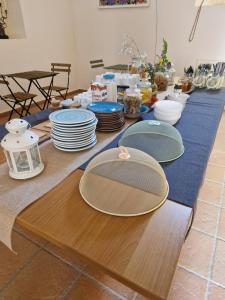 una mesa larga con platos y platos. en BB Convento Sant Antonio di Laurino, en Laurino