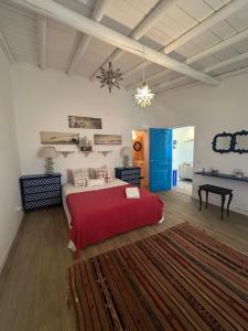 a bedroom with a large bed with a red blanket at NuriahBoutique in Boliqueime