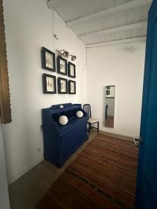 a room with a blue couch and pictures on the wall at NuriahBoutique in Boliqueime
