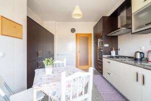a kitchen with a table and chairs in a kitchen at Porto Sea Front Apartment in Lavra
