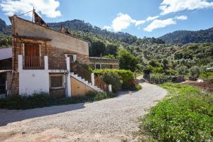 an old house on a gravel road with a mountain at Cortijo el Soto in Beas de Segura
