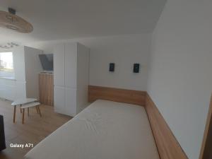 um quarto branco com uma cama e uma cadeira em Studio vue port à 50m plage em Carnon-Plage
