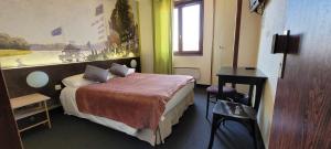 een hotelkamer met een bed en een raam bij Le Merle Blanc in Digoin