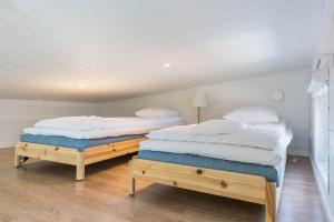 2 aparte bedden in een kamer met witte muren bij Merikruunu tähdistöhuvila Otava 15 in Dragsfjärd