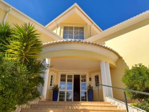 a yellow house with a palm tree at Aurora Sol in Luz