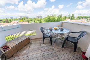 a small balcony with a table and chairs on a roof at Le Bohème de Montreuil 13 minutes Paris in Montreuil