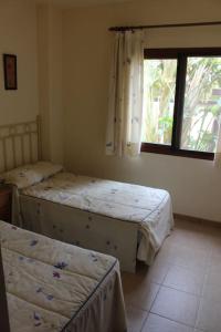 two twin beds in a room with a window at Espectacular casa Playas de Vera in Playas de Vera