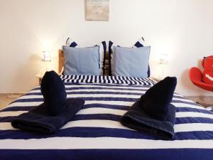 a bed with blue and white striped sheets and pillows at Ferienhaus Pomerania Gemütliches Möwennest bei Rügen in Sundhagen