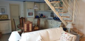 a living room with a white couch and a kitchen at Kleines Ferienhaus am Meer in Guissény
