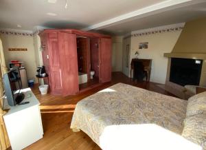 um quarto com uma cama e uma televisão num quarto em Les Suites de L'Anse em Tadoussac