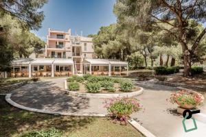 ラコナにあるHOTIDAY Hotel Isola D'Elbaの正面に庭園がある建物