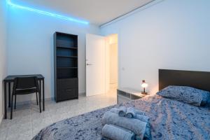 a bedroom with a bed and a desk and a chair at Modern Comfort App in Las Palmas GC in Las Palmas de Gran Canaria