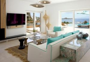 a living room with a couch and a tv at Nammos Hotel Mykonos in Psarou