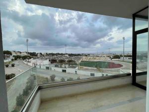 a balcony with a view of a soccer field at Spacious two room apartment with a super view in Bizerte +1 photo