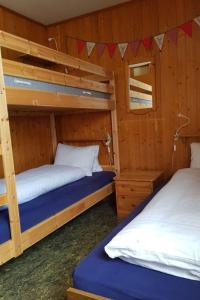 アデルボーデンにあるApartment Bodehus by Interhomeの木製の壁の客室で、二段ベッド2組が備わります。