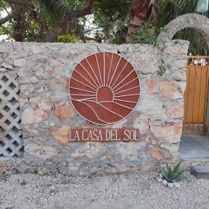 un panneau indiquant la casa del sol sur un mur en pierre dans l'établissement La Casa del Sol, à El Cuyo