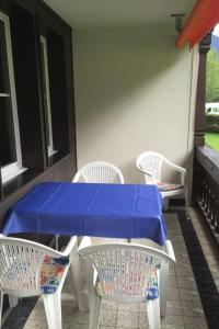 グスタードにあるApartment Oberland Nr- 19 by Interhomeの青いテーブルと椅子が備わるパティオ