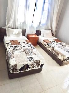 zwei Betten nebeneinander in einem Zimmer in der Unterkunft Villa Serene Oasis in Aït Ali