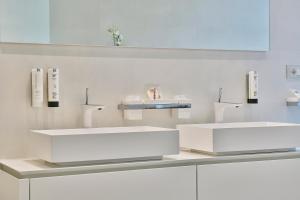 two white sinks in a white bathroom at Wosching Haus Roemer Living in Merano