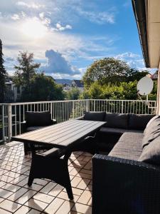 a patio with a wooden table and a couch at Stilvolles Apartment am ICE Bahnhof in Kassel