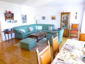 a living room with a blue couch and a table at Apartment Vermala Soleil B 13 by Interhome in Crans-Montana