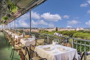 una fila di tavoli sul balcone di un ristorante di Hotel Splendide Royal - The Leading Hotels of the World a Roma