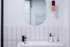 a white bathroom with a mirror and a sink at Glow Apartments, Apartamenty Nowa Letnica in Gdańsk