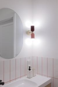 uma casa de banho com um espelho e um lavatório em Glow Apartments, Apartamenty Nowa Letnica em Gdansk