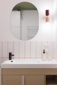 a bathroom with a sink and a mirror at Glow Apartments, Apartamenty Nowa Letnica in Gdańsk