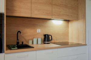 uma cozinha com um lavatório e comodidades para preparar café em Glow Apartments, Apartamenty Nowa Letnica em Gdansk