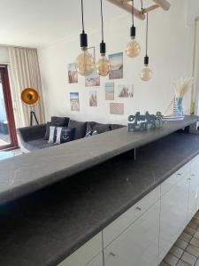 a living room with a long gray counter top at Ankerplatz - gemütliches Ferienhaus mit Garten und Terrasse für die große Familie in Grömitz +11 photos