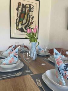 a table with plates and glasses and a vase with flowers at Ankerplatz - gemütliches Ferienhaus mit Garten und Terrasse für die große Familie in Grömitz