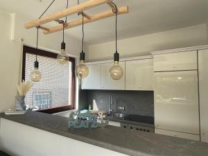 a kitchen with several lights hanging over a counter at Ankerplatz - gemütliches Ferienhaus mit Garten und Terrasse für die große Familie in Grömitz +11 photos