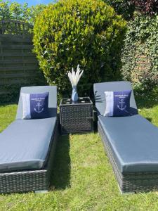two beds sitting in the grass with a vase at Ankerplatz - gemütliches Ferienhaus mit Garten und Terrasse für die große Familie in Grömitz