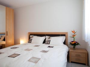 a bedroom with a bed with white sheets and pillows at Apartment Iris A-3 by Interhome in Leukerbad