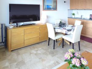 a living room with a table and a large television at Apartment Clairière des Barzettes B16 by Interhome in Crans-Montana +22 photos