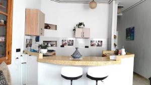 a kitchen with a counter with stools and a counter top at SARA HOUSE NADOR in Nador